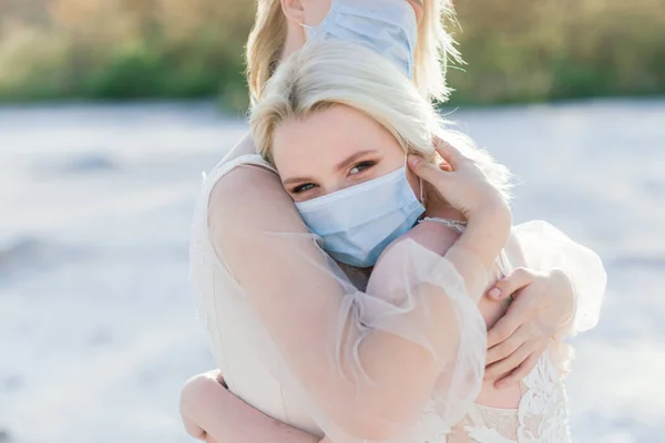 Lesbian couple wedding on white sand, wear masks to prevent epidemic COVID-19