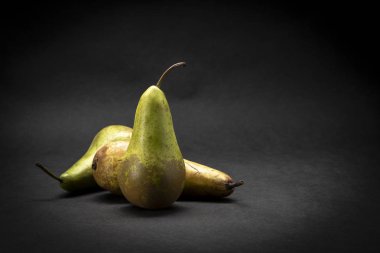 karanlık bir arka plan üzerinde armut natürmort