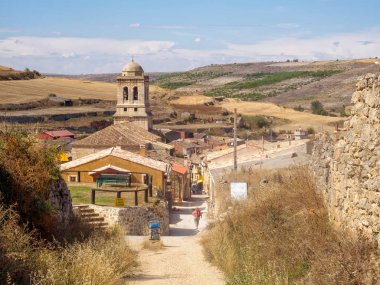 Belltower of the 16th century parish church of the Conception tucked down in a small valley of the Meseta - Hontanas, Castile and Leon, Spain, 14 September 2014 clipart