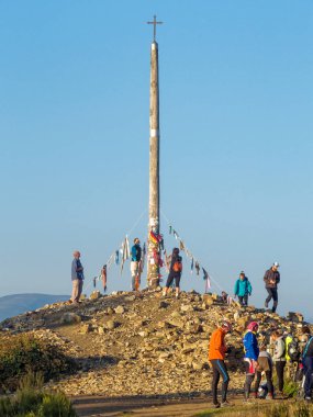 Pilgrims leave their stones and other mementos around Cruz de Ferro, an iron cross on top of a weathered pole - Puerto Irago, Castile and Leon, Spain, 25 September 2014 clipart