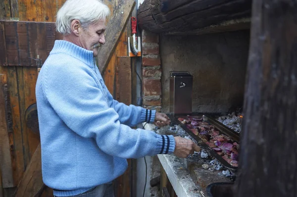 バーベキュー グリルで肉を料理年配の男性 — ストック写真