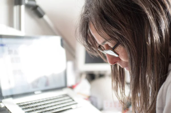 caucasian lady, in home working office desk, with documents, laptop, smartphone