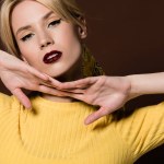 Portrait of beautiful sensual blonde woman looking at camera isolated on brown