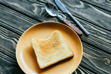Tost ekmeğine çatal bıçak takımı ahşap masa üzerinde plaka üzerinde