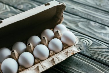 Ahşap masa üzerinde beyaz yumurta karton kutu