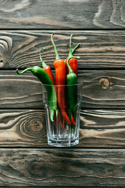 Groene Rode Chilipepertjes Glas Houten Tafel — Gratis stockfoto