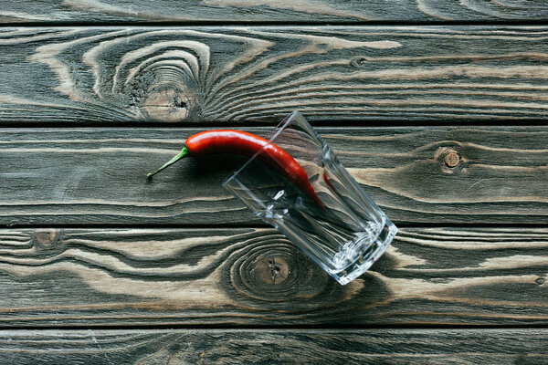 Red chili pepper in glass on wooden table
