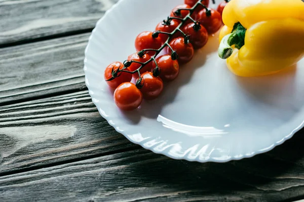 木桌上有樱桃西红柿和甜椒的盘子 — 免费的图库照片