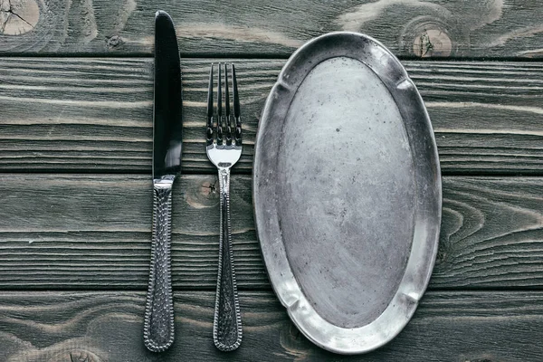 ナイフとフォークを木製のテーブルのシルバー トレイ — ストック写真