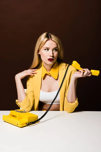 Attractive Blonde Girl Holding Yellow Handset Looking Away Brown — Stock Photo, Image