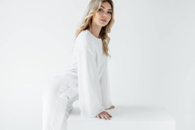 güzel sarışın kadın beyaz giyim üzerine beyaz izole kamera bakıyor yan görünüm