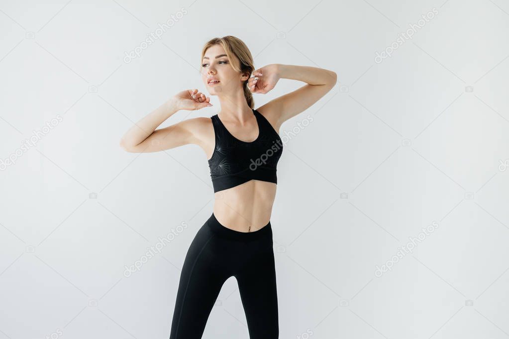 portrait of young athletic sportswoman looking away on grey backdrop