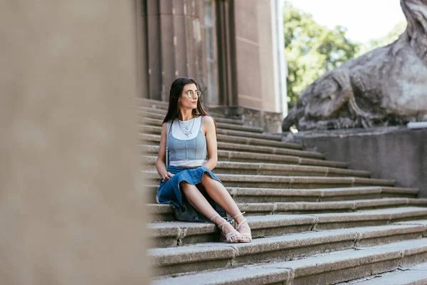 Selective Focus Girl Eyeglasses Sitting Stairs Looking Away — Free Stock Photo