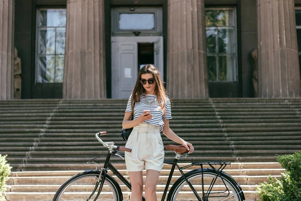 Attractive Girl Sunglasses Using Smartphone While Standing Bike Beautiful Building — Stock Photo, Image