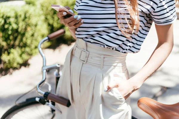 Ritagliato Colpo Ragazza Utilizzando Smartphone Mentre Piedi Con Bicicletta Sulla — Foto stock gratuita