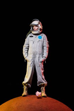 astronot uzay giysisi ve şakayık gezegende kask ayakta