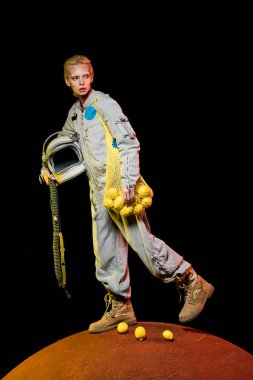 kask ve limon kırmızı gezegen üzerinde tutarak uzay giysisi içinde çekici kadın astronot 