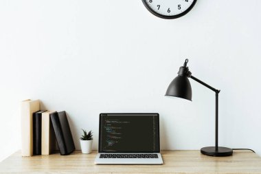 Laptop ile program kodu ve kitap ofis çalışma masası