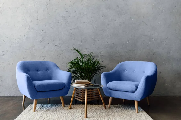 现代室内的蓝色扶手椅 桌子与书籍和植物 — 图库照片