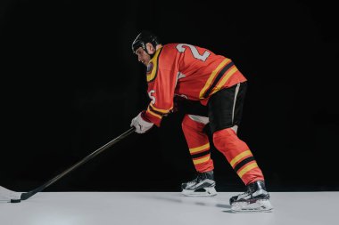 side view of professional sportsman playing hockey on black clipart
