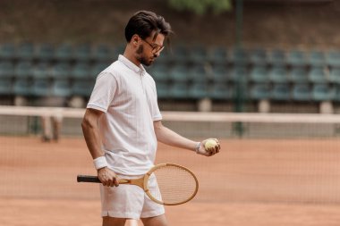 tenis top ve Raket Mahkemesi ile ayakta yakışıklı retro tarz tenis oyuncusu