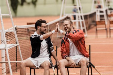 Tenis Kortu, çak bir beşlik vererek retro tarz tenisçiler gülümseyen