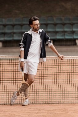 Tenis Kortu, net üzerinde yaslanmış ve uzağa bakarak tenisçi yakışıklı retro tarz