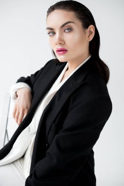 siyah şık ceket gri izole sandalyeye oturmuş güzel baştan çıkarıcı Bayan portresi
