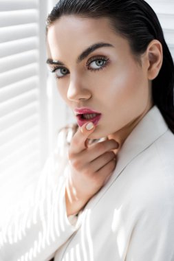 baştan çıkarıcı esmer model beyaz takım elbiseli poz