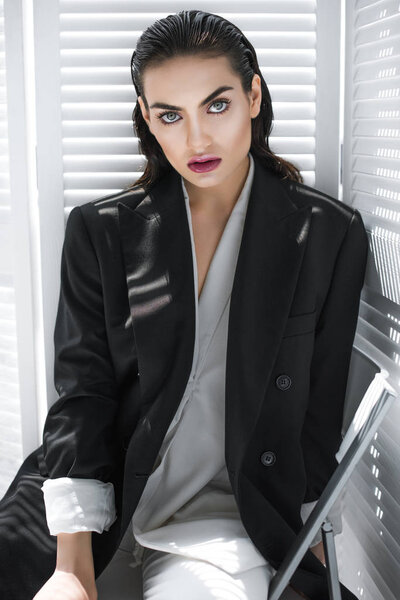 elegant fashionable girl with makeup posing in black jacket 