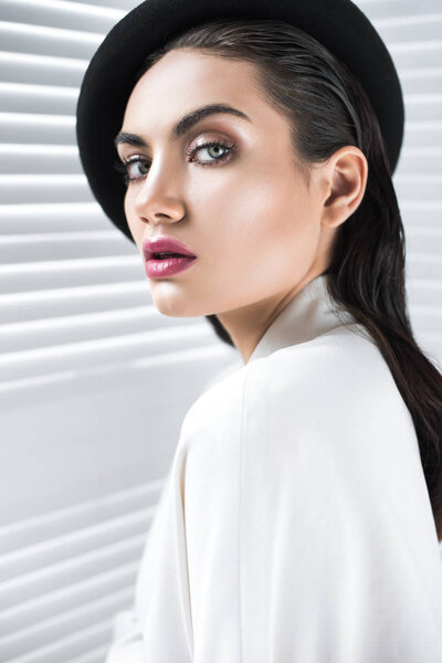 fashionable woman with glamour makeup posing in beret and elegant white jacket