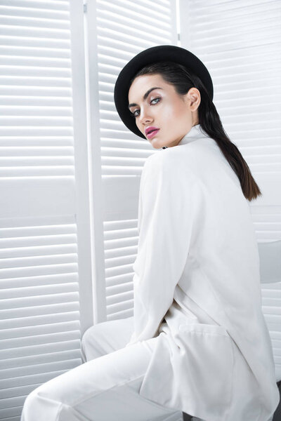 seductive young woman posing in beret and white fashionable jacket