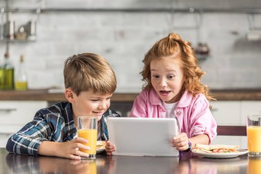 küçük kardeşi ve kız kardeşi tablet kahvaltı sırasında kullanma şaşırttı