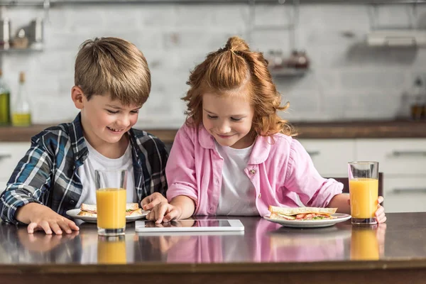 Szczęśliwy Mały Brat Siostra Pomocą Tabletu Podczas Śniadania Kuchni — Zdjęcie stockowe