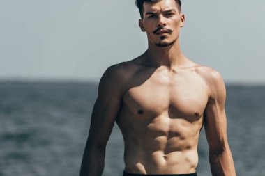 kamera önünde denize bakarak yakışıklı atletik erkek