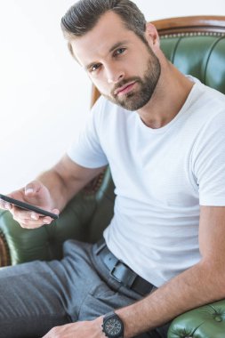 koltukta, otururken Smartphone kullanarak zarif sakallı adam beyaz izole