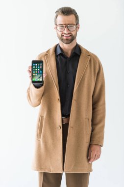 iphone üzerinde beyaz izole, sunma paltolu gülümseyen adam sakallı