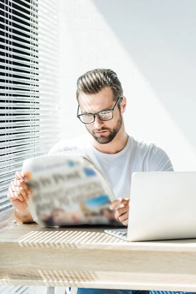 Schöner Geschäftsmann Liest Zeitung Arbeitsplatz Mit Laptop — Stockfoto