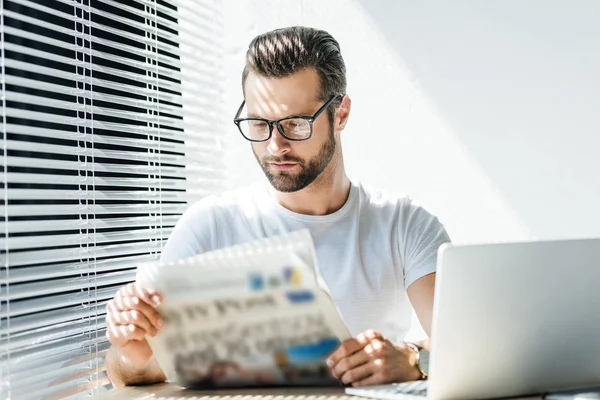 Brunetta Uomo Leggendo Giornale Sul Posto Lavoro Con Computer Portatile — Foto Stock