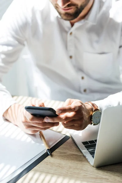 Ausgeschnittene Ansicht Eines Geschäftsmannes Mit Smartphone Arbeitsplatz Mit Laptop Und — Stockfoto