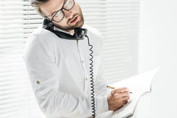 Bonito Empresário Falando Telefone Rotativo Enquanto Escrevendo Notebook — Fotos gratuitas