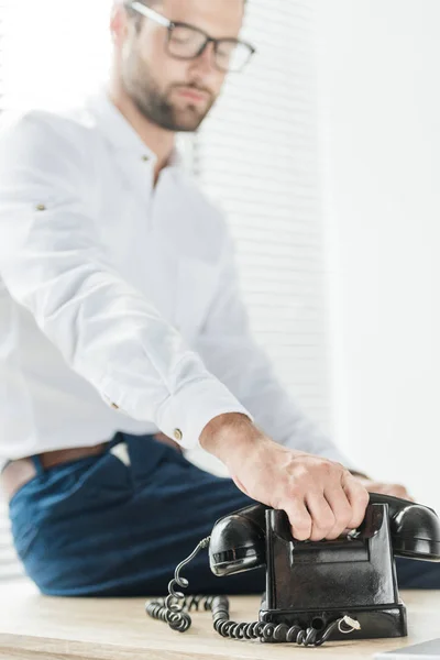 Selective Focus Businessman Sitting Table Holding Rotary Telephone — Free Stock Photo