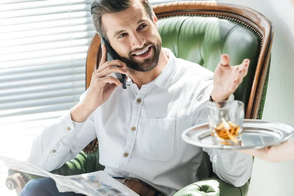 Bearded Man Newspaper Talking Smartphone While Taking Whiskey Glass Tray — Stock Photo, Image