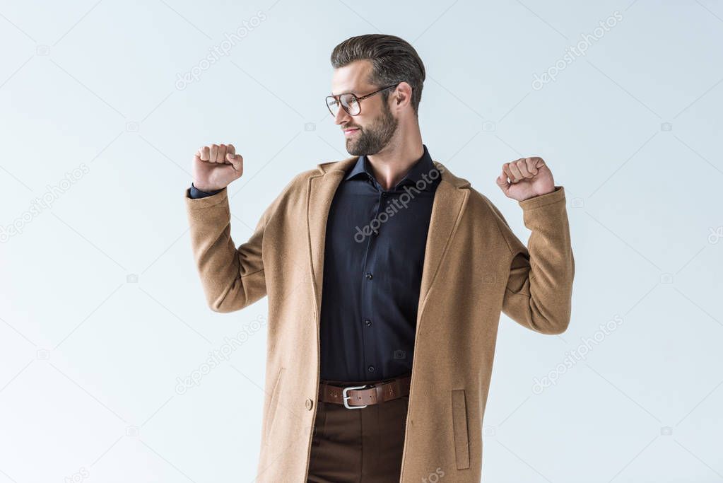 excited man gesturing and posing in autumn brown coat, isolated on white