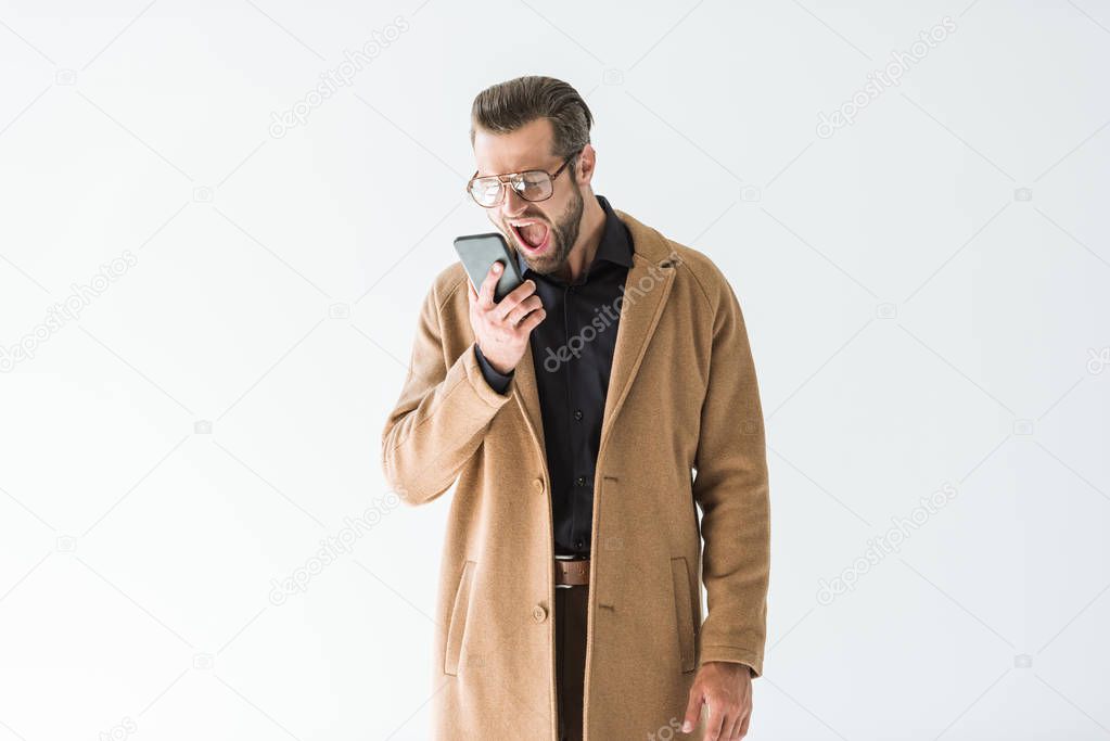 angry man in autumn outfit yelling at smartphone, isolated on white
