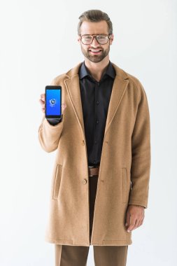 gözlük ve kat üzerinde beyaz izole shazam cihazı ile smartphone sunan şık adam