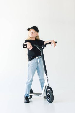 scooter ile ayakta ve dış saha üzerinde izole beyaz arıyorum uzun kıvırcık saçlı çocuk görünümünü tam uzunlukta