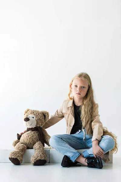 美丽的孩子看着相机 而坐在白色的泰迪熊 — 图库照片