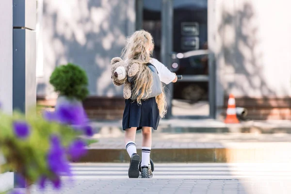 Vista Trasera Adorable Escolar Con Mochila Oso Peluche Scooter Calle — Foto de Stock