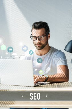 bearded developer working with laptop with SEO icons clipart